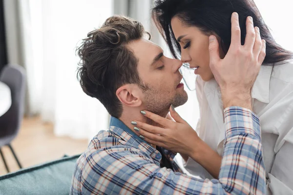 Beautiful woman kissing handsome boyfriend at home — Stock Photo
