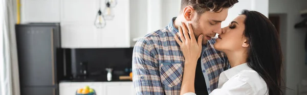 Panoramic orientation of attractive girl kissing handsome boyfriend at home — Stock Photo