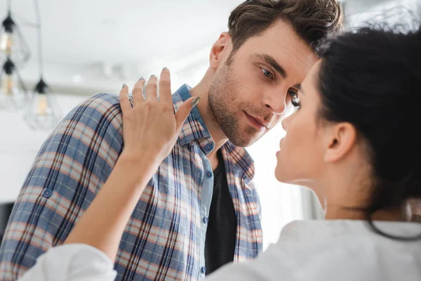 Selective focus of woman touching handsome man at home — Stock Photo