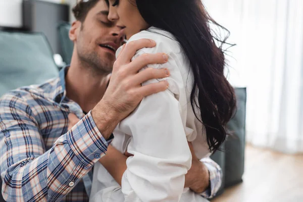 Focus selettivo dell'uomo che abbraccia la fidanzata sensuale in soggiorno — Foto stock