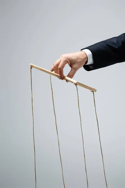 Cropped view of puppeteer holding marionette isolated on grey — Stock Photo