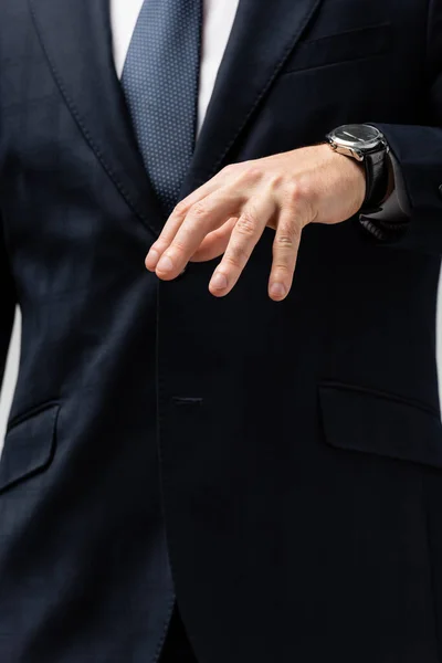 Vista recortada de hombre de negocios en traje manipulando con la mano aislada en gris - foto de stock