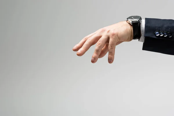 Cropped view of businessman manipulating with hand isolated on grey — Stock Photo