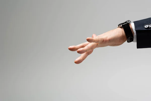 Cropped view of businessman manipulating with hand isolated on grey — Stock Photo