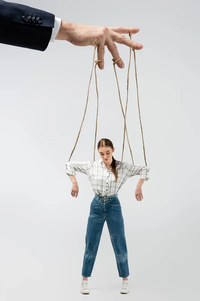 Cropped view of puppeteer holding marionette on strings isolated on grey — Stock Photo