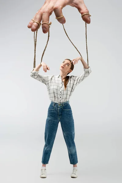 Cropped view of puppeteer holding marionette on strings isolated on grey — Stock Photo