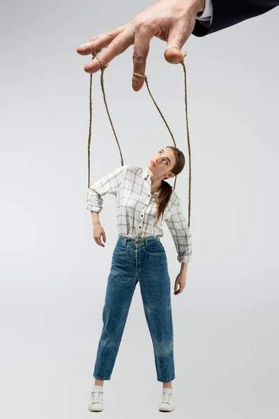 Cropped view of puppeteer holding marionette on strings isolated on grey — Stock Photo