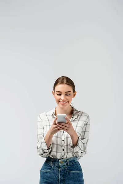 Привлекательная девушка с помощью смартфона, изолированного на сером — стоковое фото