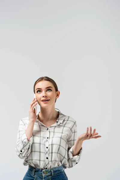 Chica atractiva usando teléfono inteligente aislado en gris - foto de stock