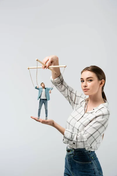 Female puppeteer holding male marionette isolated on grey — Stock Photo