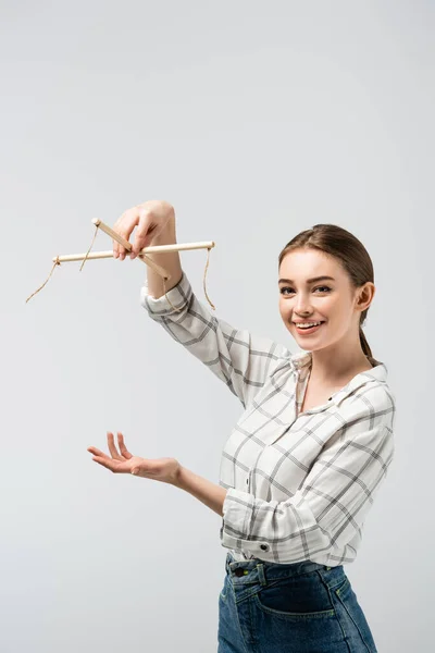 Smiling attractive female puppeteer pointing with hand isolated on grey — Stock Photo