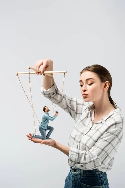 Female puppeteer kissing male marionette with ring box isolated on grey — Stock Photo