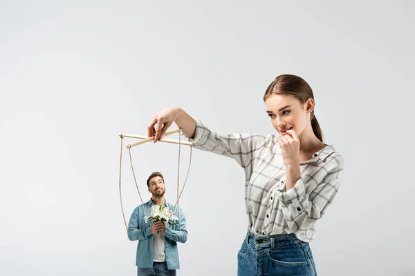 Titiritero femenino sosteniendo marioneta masculina con flores aisladas en gris - foto de stock