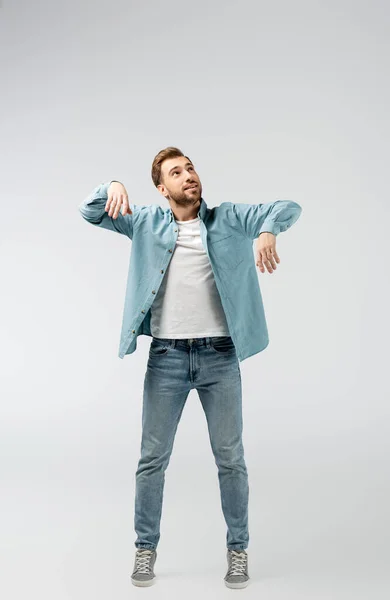 Jeune homme posant comme une marionnette isolée sur gris — Photo de stock