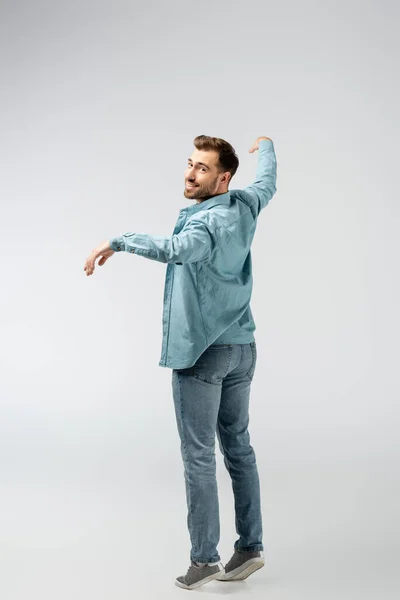 Young man posing like puppet isolated on grey — Stock Photo