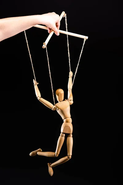 Cropped view of puppeteer holding wooden marionette isolated on black — Stock Photo