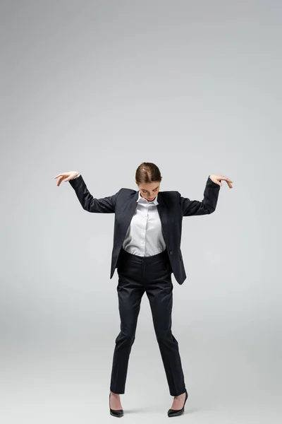 Бізнес-леді маріонетка в костюмі позує ізольовано на сірому — стокове фото