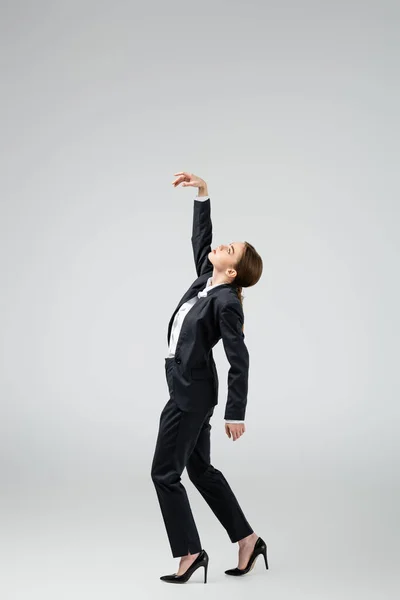 Side view of businesswoman marionette in suit posing isolated on grey — Stock Photo