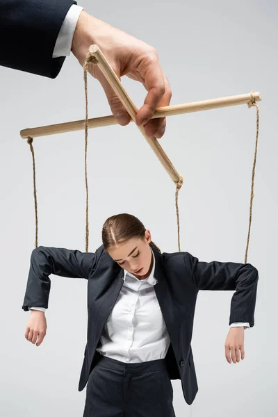 Cropped view of puppeteer holding businesswoman marionette on strings isolated on grey — Stock Photo