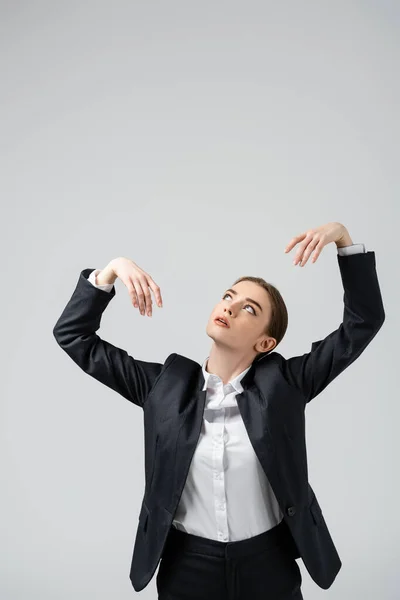 Mujer de negocios marioneta en traje posando aislado en gris - foto de stock