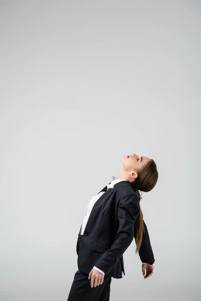 Side view of businesswoman marionette in suit posing isolated on grey — Stock Photo