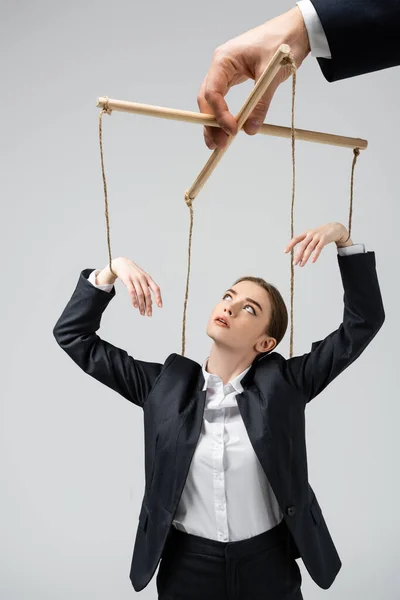 Vista ritagliata di burattinaio azienda donna d'affari marionetta su corde isolate su grigio — Foto stock