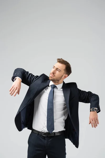 Hombre de negocios marioneta en traje posando con las manos abajo aislado en gris - foto de stock