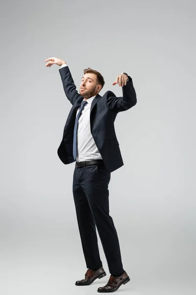 Homme d'affaires marionnette en costume posant avec les mains levées isolé sur gris — Photo de stock