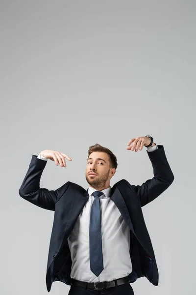 Businessman marionette in suit with raised hands isolated on grey — Stock Photo