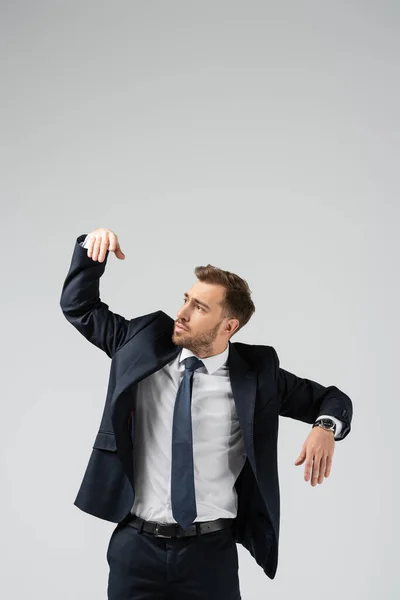 Businessman marionette in suit with raised hand isolated on grey — Stock Photo