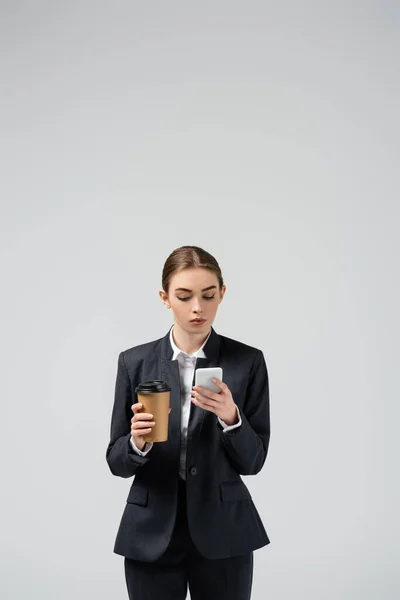 Young businesswoman with coffee to go isolated on grey — Stock Photo