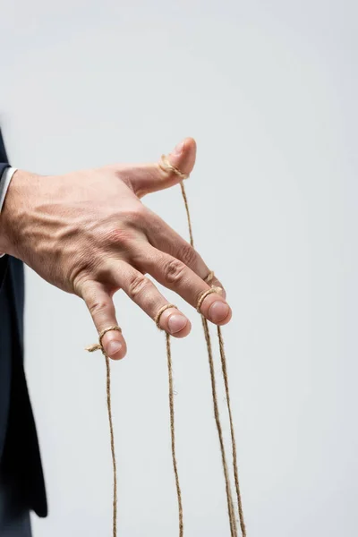 Vue partielle du marionnettiste avec des cordes sur les doigts isolés sur le gris — Photo de stock