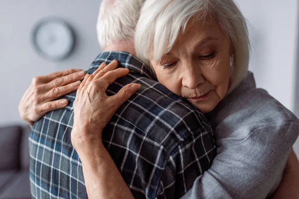 Пожилая женщина с закрытыми глазами, обнимающая мужа, больного слабоумием — стоковое фото