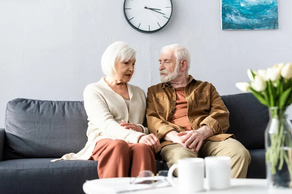 Selective focus of senior couple talking while sitting on sofa — Stock Photo
