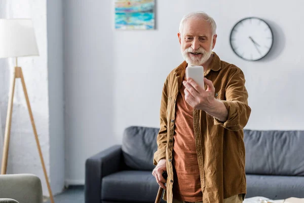 Fröhlicher älterer Mann lächelt beim Selfie mit dem Smartphone — Stockfoto