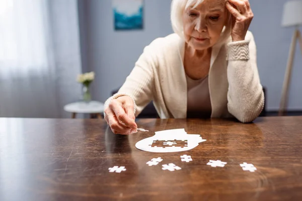 Senior woman combining jigsaw puzzle for dementia rehabilitation — Stock Photo