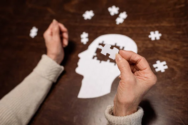 Ausgeschnittene Ansicht einer Frau, die Puzzle als Demenztherapie sammelt — Stockfoto
