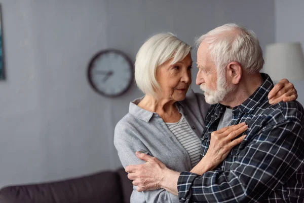 Старша жінка обіймає чоловіка, хворий на деменцію, стоячи обличчям до обличчя — стокове фото