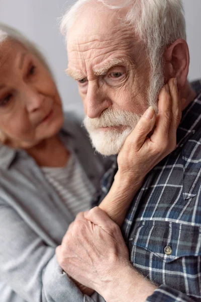 Senior woman touching face of husband suffering from dementia — Stock Photo