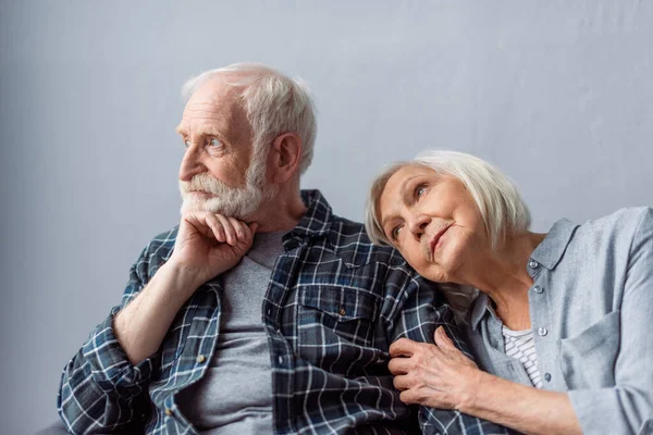 Dreamy senior woman leaning on shoulder of thoughtful husband looking away — Stock Photo