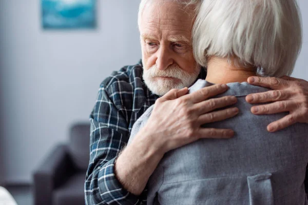 Rückansicht einer Seniorin, die von ihrem Mann umarmt wird und an Demenz erkrankt ist — Stockfoto