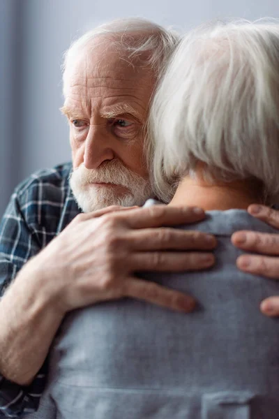 Senior leidet an Demenz, umarmt Ehefrau und schaut weg — Stockfoto