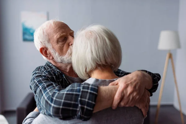 Senior man hugging and kissing wife, suffering from alzheimer disease — Stock Photo