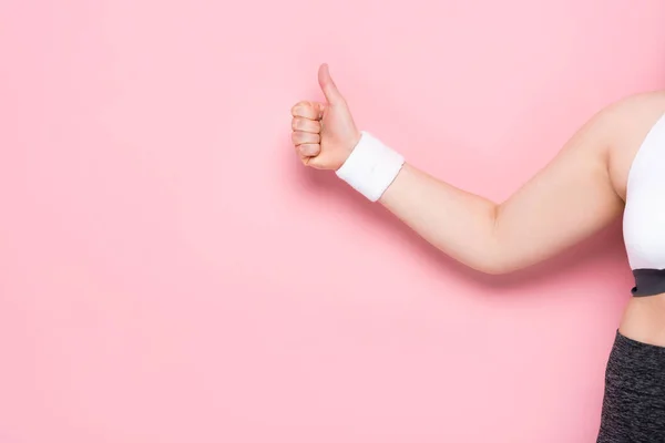 Обрізаний вид дівчини з надмірною вагою, що показує великий палець на рожевому — стокове фото