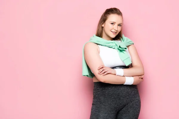 Hübsches übergewichtiges Mädchen mit Sweatshirt über den Schultern lächelt in die Kamera auf rosa — Stockfoto