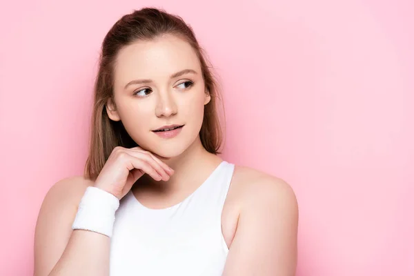 Thoughtful overweight girl holding hand near chin while looking away on pink — Stock Photo