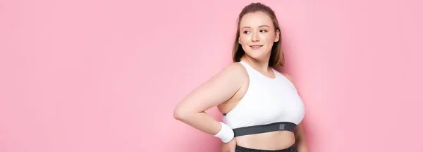 Website-Header eines attraktiven übergewichtigen Mädchens, das mit der Hand auf der Hüfte auf rosa steht — Stockfoto
