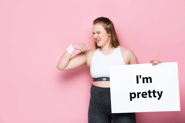 Menina com sobrepeso descontente sorrindo enquanto segurando cartaz com eu sou muito inscrição em rosa — Fotografia de Stock