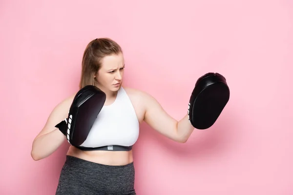 Seriöse Größe plus Mädchentraining in Boxkissen auf rosa — Stockfoto