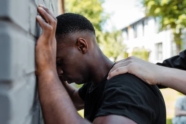 Selective focus of policeman detaining african american man on street, racism concept — Stock Photo